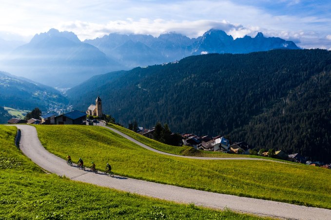 Biking in Val Comelico con la chiesetta di S.Leonardo sullo sfondo, Dolomitii (BL), Veneto, Italy